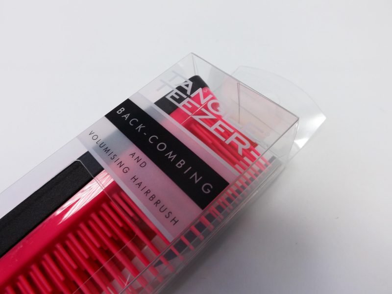 A cutout clear plastic packaging box for a hairbrush