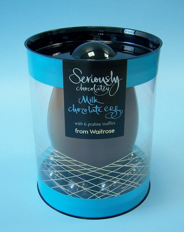 black and blue luxury chocolate easter egg in cylindrical acetate packaging.